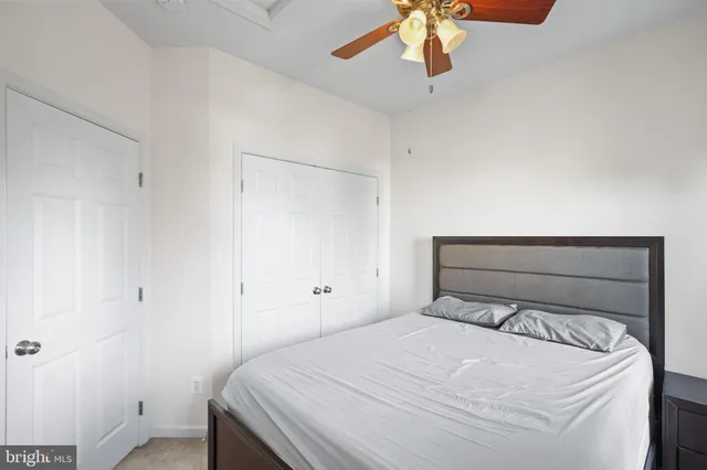a bedroom with a bed and a chandelier fan