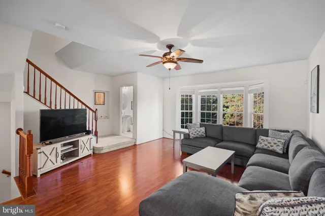 a living room with furniture ceiling fan and a flat screen tv
