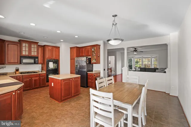 a dining room with wooden floor a chandelier a wooden table and chairs