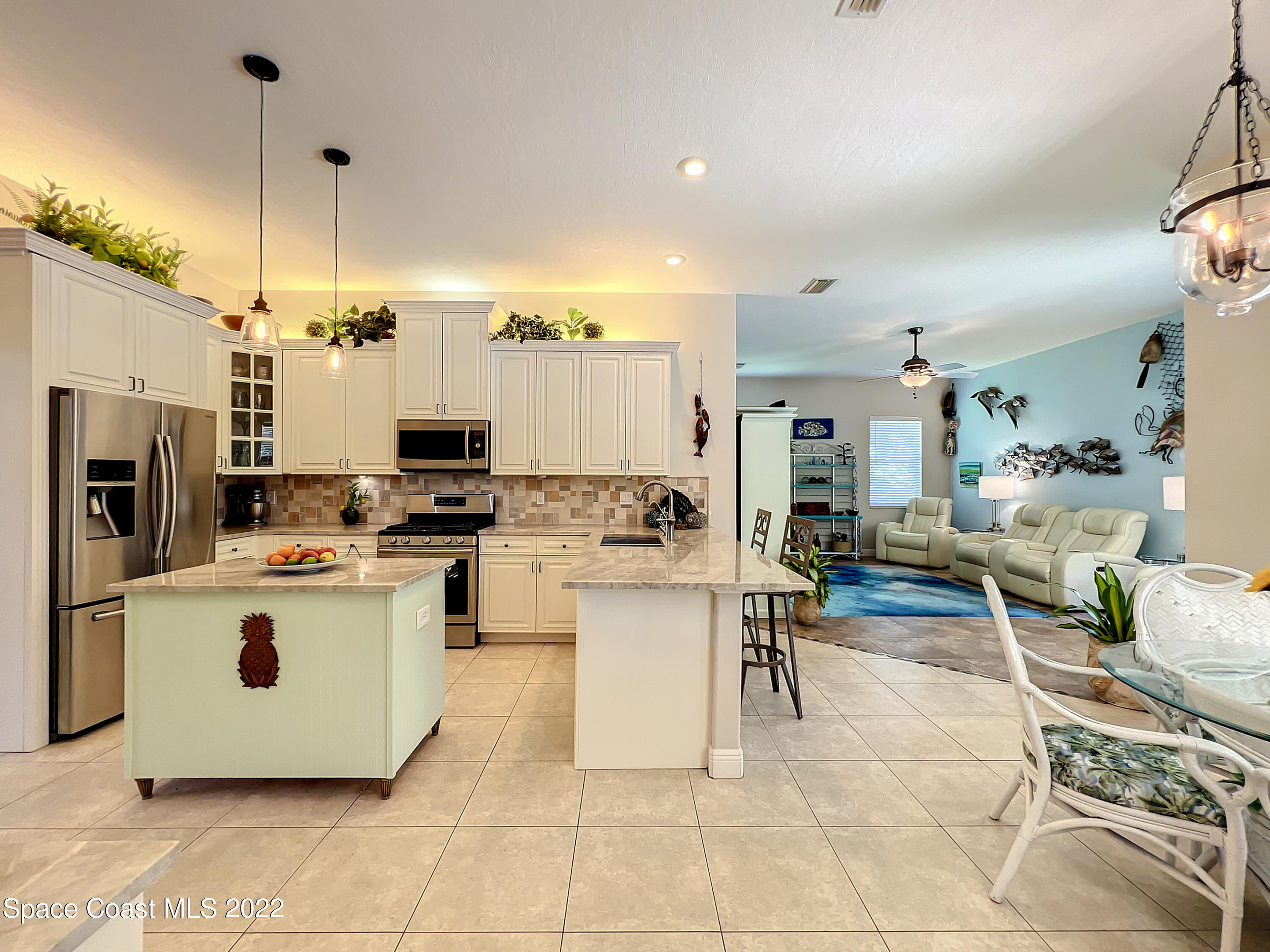 1705 Winding Ridge Circle Southeast Palm Bay, FL 32909 - Photo 13 of 45 a kitchen with a stove a refrigerator and chairs
