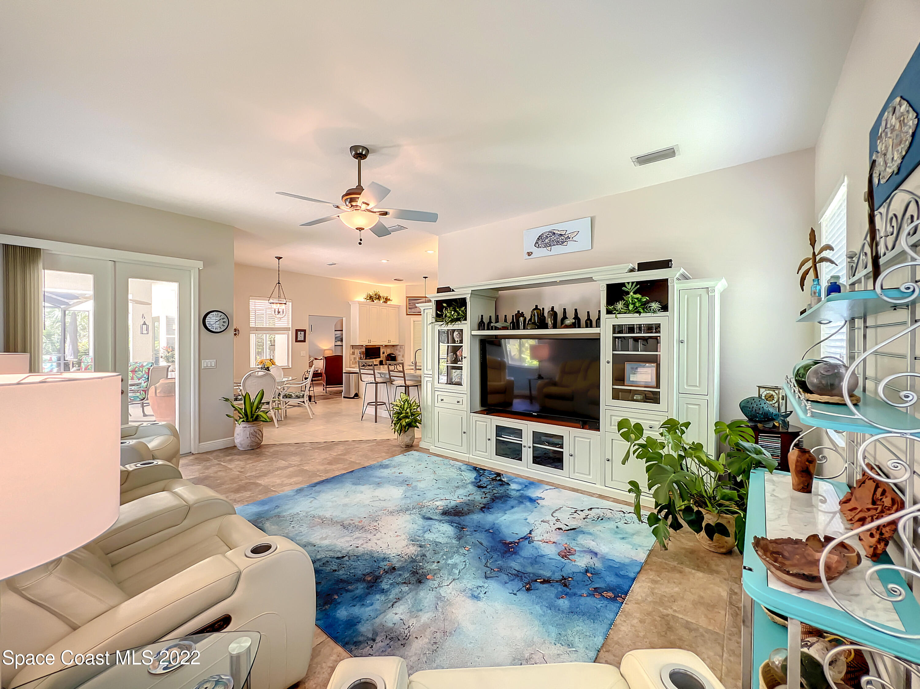 1705 Winding Ridge Circle Southeast Palm Bay, FL 32909 - Photo 16 of 45 a living room with furniture a flat screen tv and a potted plant