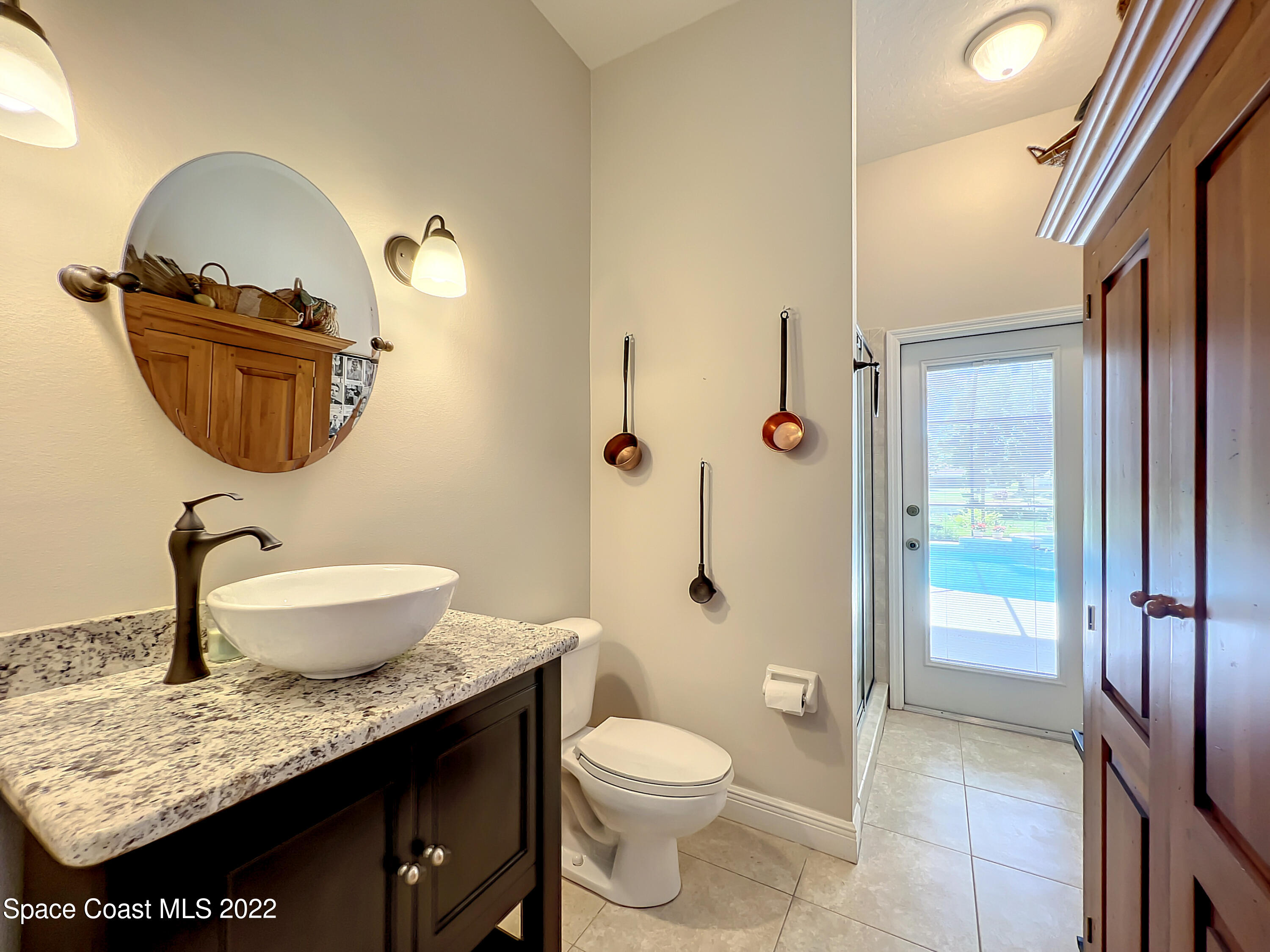 1705 Winding Ridge Circle Southeast Palm Bay, FL 32909 - Photo 29 of 45 a bathroom with a granite countertop sink a toilet and shower