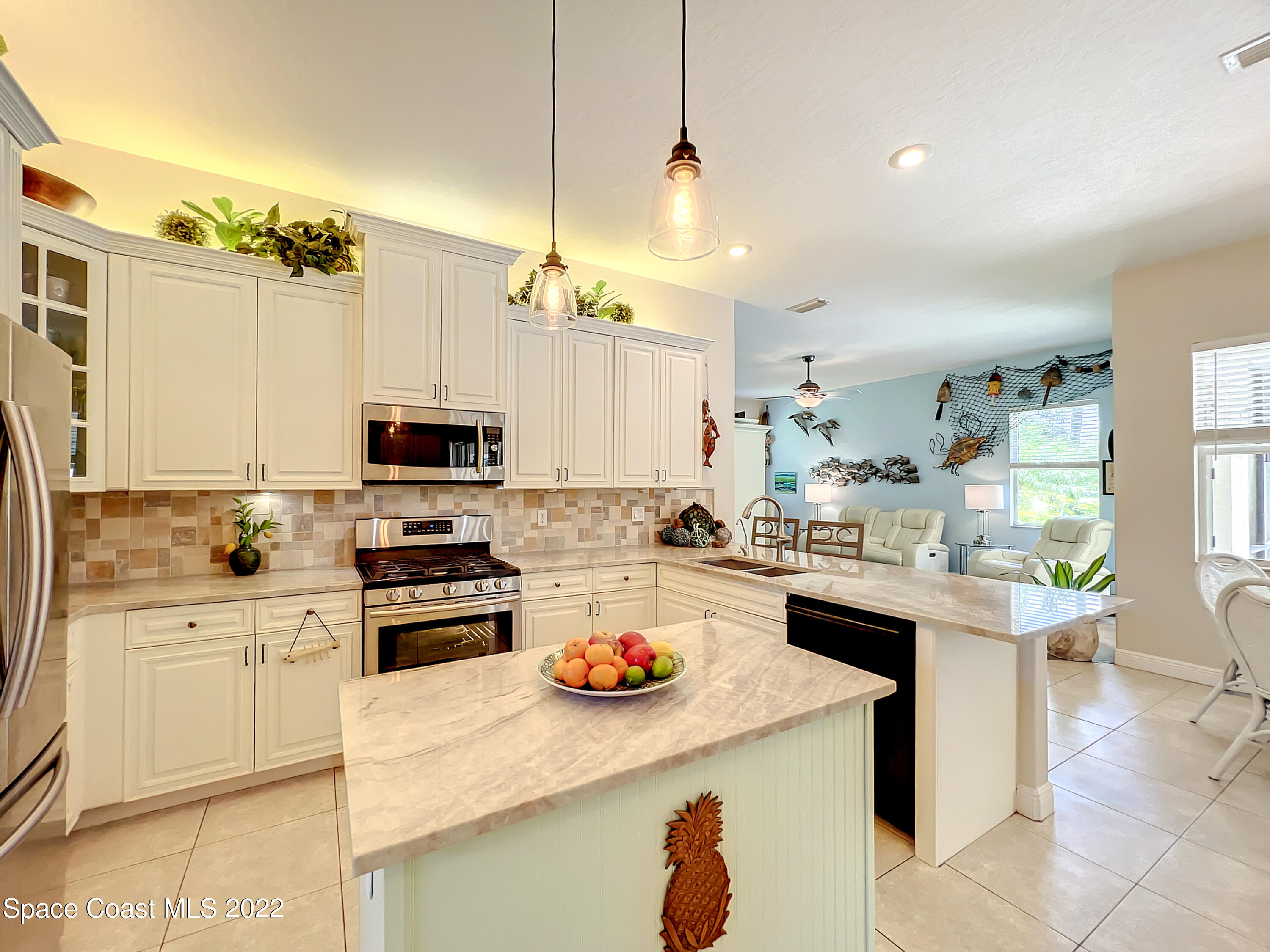 1705 Winding Ridge Circle Southeast Palm Bay, FL 32909 - Photo 10 of 45 a kitchen with a sink a stove and chairs