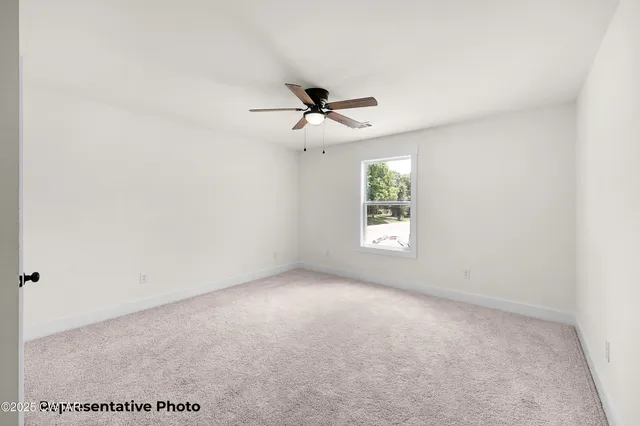 a view of a room with a ceiling fan and window