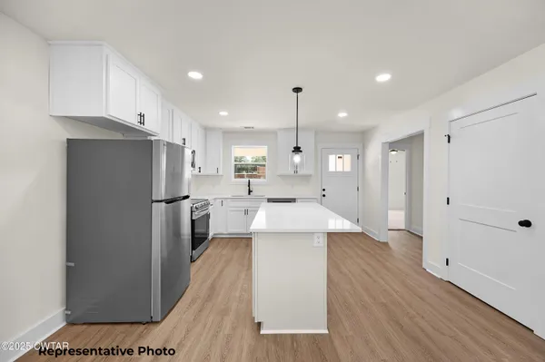 a kitchen with stainless steel appliances a refrigerator sink and cabinets