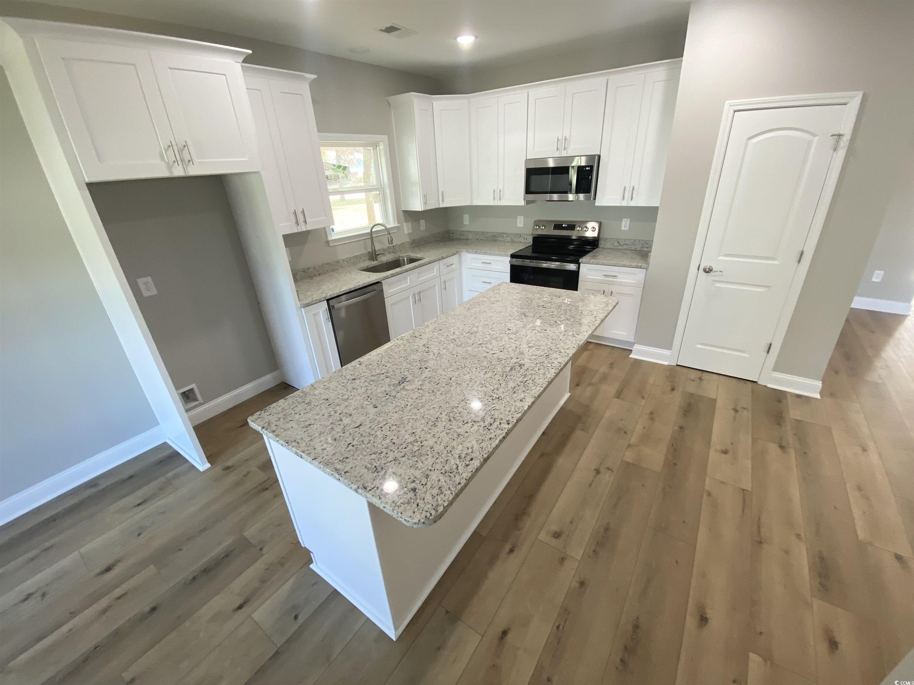 348 Jay Street Murrells Inlet, SC 29576 - Photo 4 of 29 Kitchen featuring white cabinetry, a center island