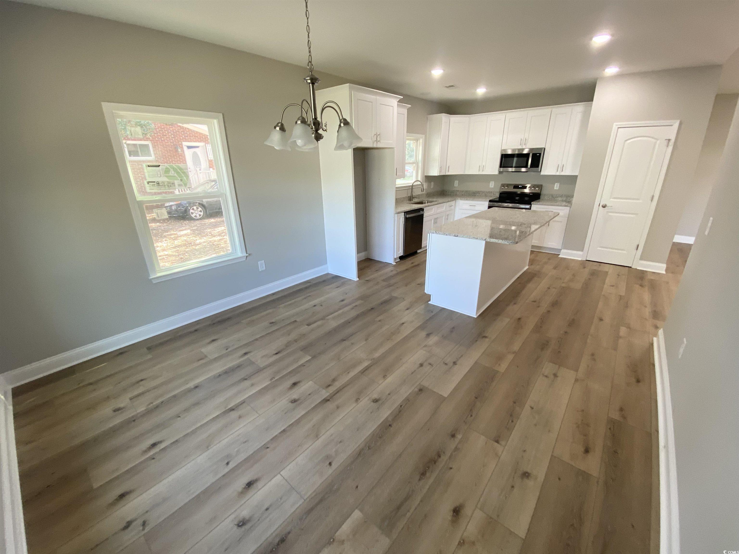 348 Jay Street Murrells Inlet, SC 29576 - Photo 8 of 29 Kitchen featuring white cabinetry, light hardwood