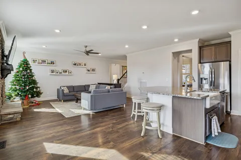 a kitchen with stainless steel appliances granite countertop a sink stove refrigerator and cabinets