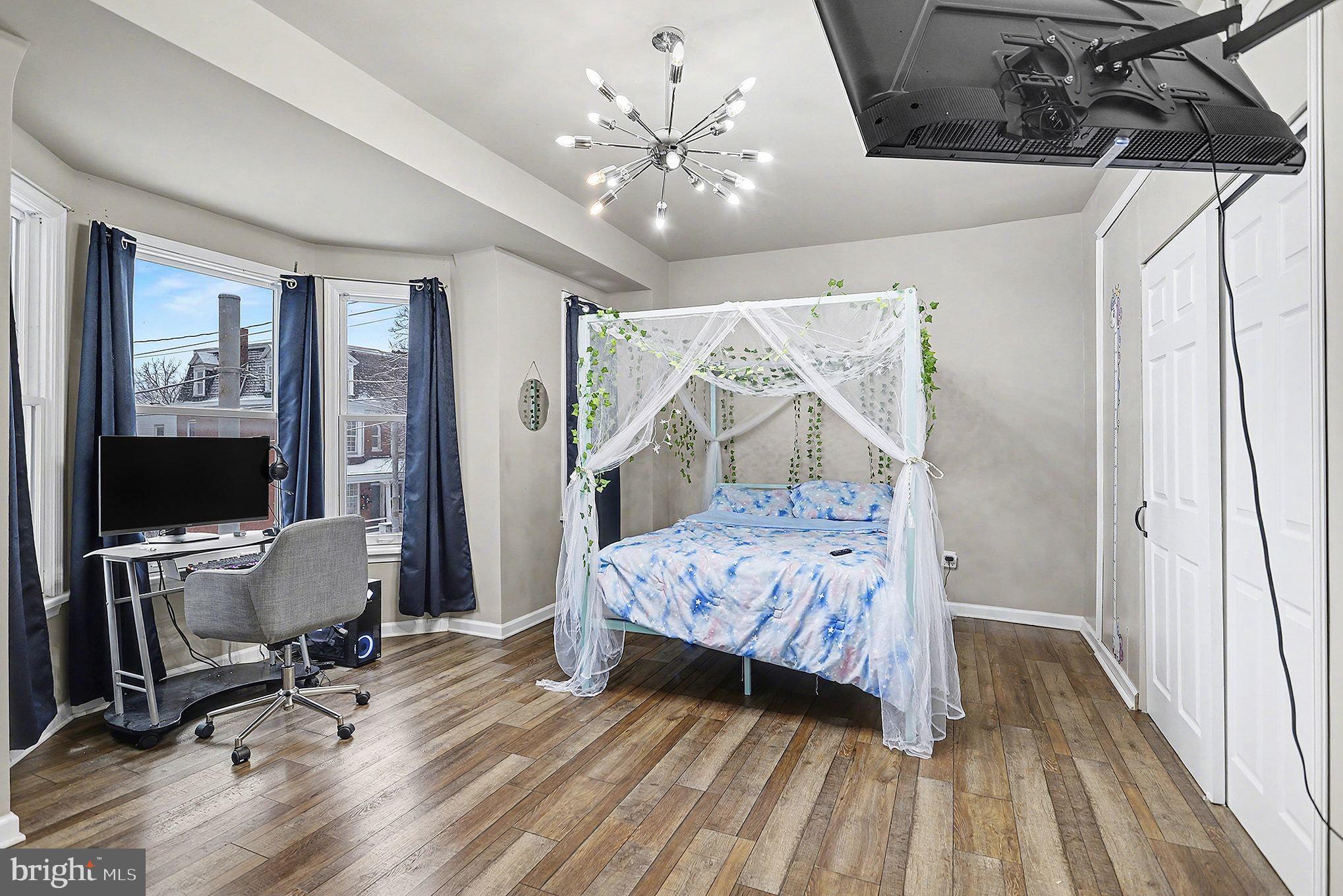 669 West Princess Street York, PA 17401 - Photo 17 of 33 a bedroom with a large bed and a chandelier