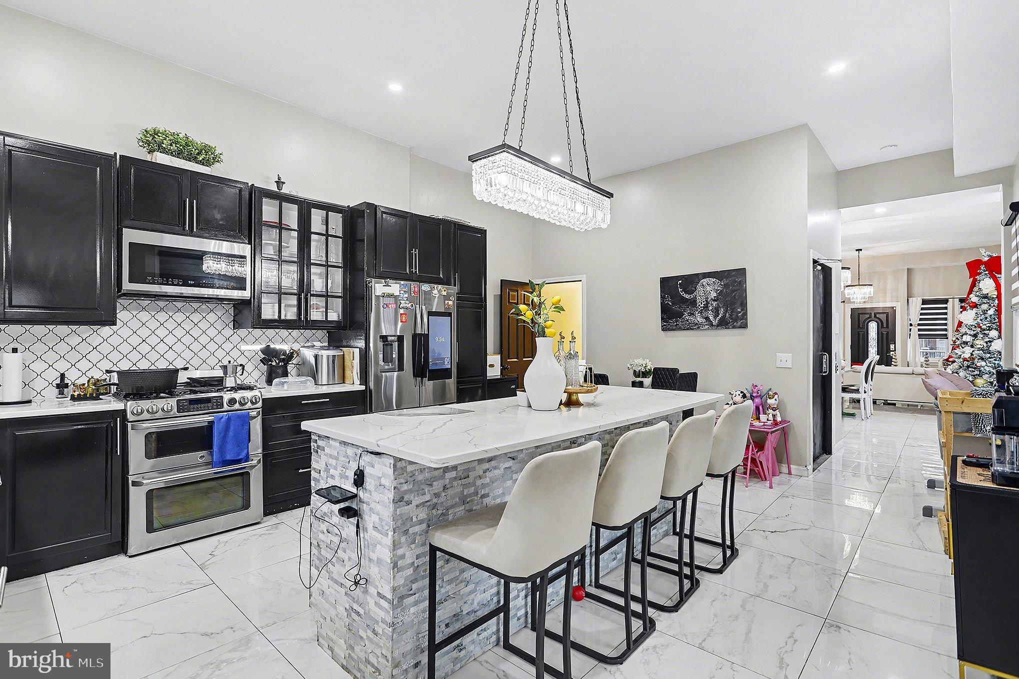669 West Princess Street York, PA 17401 - Photo 9 of 33 a kitchen with stainless steel appliances granite countertop a stove top oven a sink a stove a dining table and chairs
