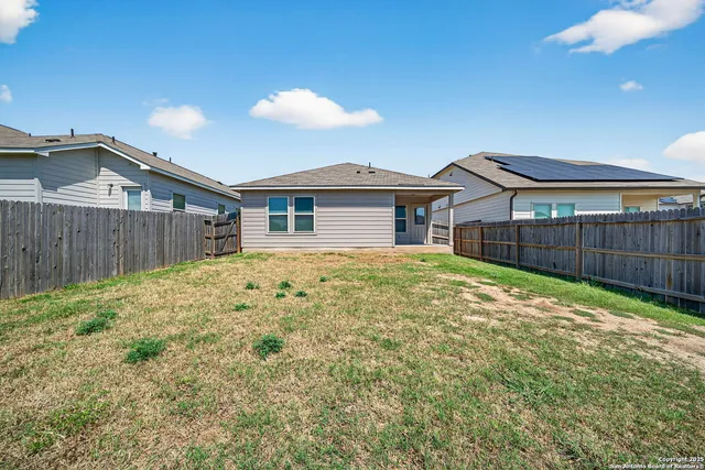 a view of a house with a yard and wooden fence