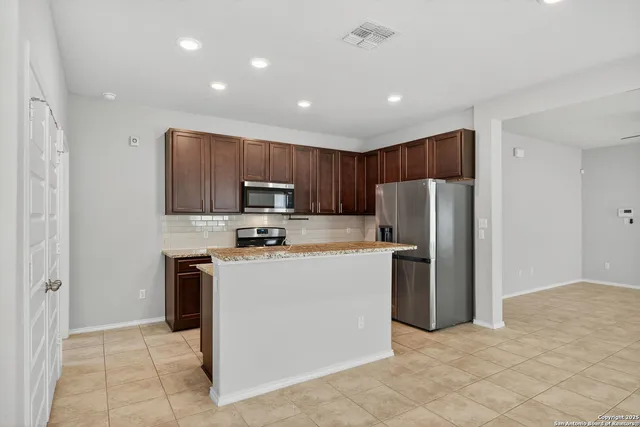 a kitchen with stainless steel appliances granite countertop a refrigerator stove a sink and a microwave