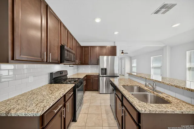 a kitchen with a sink stove top oven and refrigerator