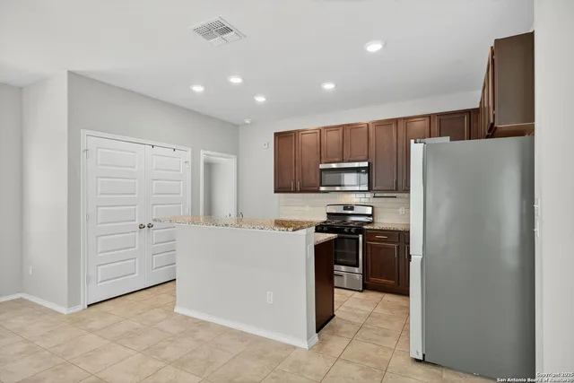 a kitchen with cabinets and stainless steel appliances