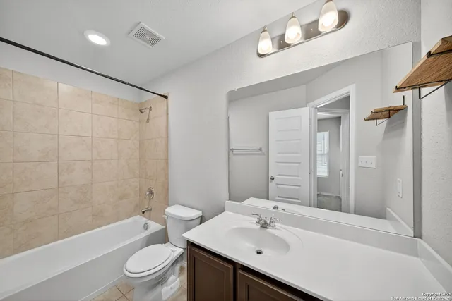 a bathroom with a sink a toilet a mirror a bathtub and shower