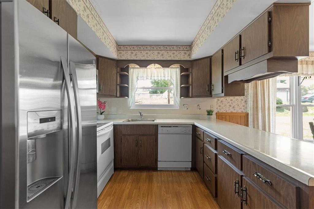 1891 Concord Drive Ambridge, PA 15003 - Photo 7 of 40 a kitchen with stainless steel appliances granite countertop a refrigerator a sink dishwasher a stove and white countertops with wooden floor