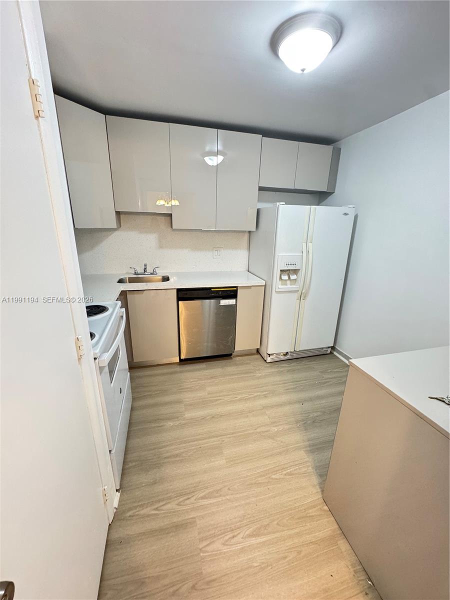 4160 Inverrary Drive, Unit 510 Lauderhill, FL 33319 - Photo 3 of 25 a view of a kitchen with refrigerator stove and wooden cabinets