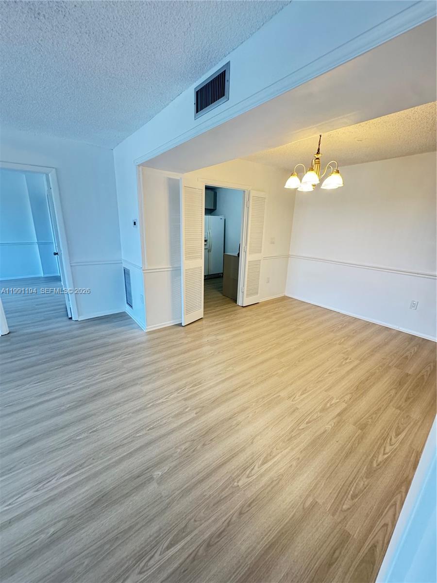 4160 Inverrary Drive, Unit 510 Lauderhill, FL 33319 - Photo 6 of 25 a view of an empty room with wooden floor and a ceiling fan