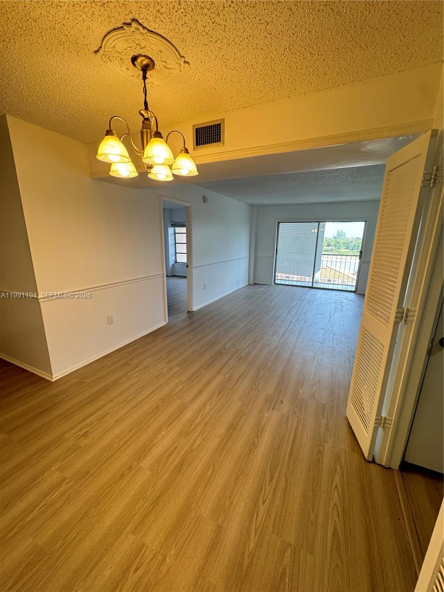 4160 Inverrary Drive, Unit 510 Lauderhill, FL 33319 - Photo 9 of 25 a view of a livingroom with a chandelier fan and wooden floor