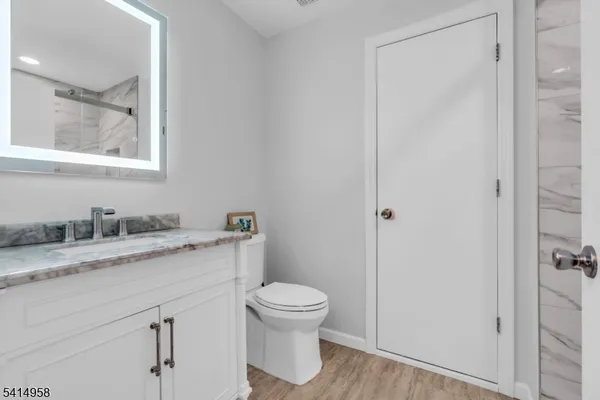 a bathroom with a granite countertop sink toilet and shower