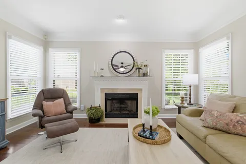 a living room with furniture a fireplace a large window and a fireplace