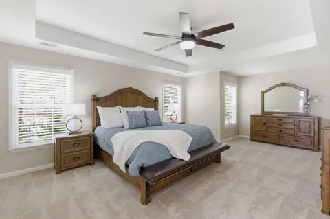 a spacious bedroom with a bed a chandelier and a window