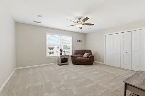 a living room with furniture and a ceiling fan