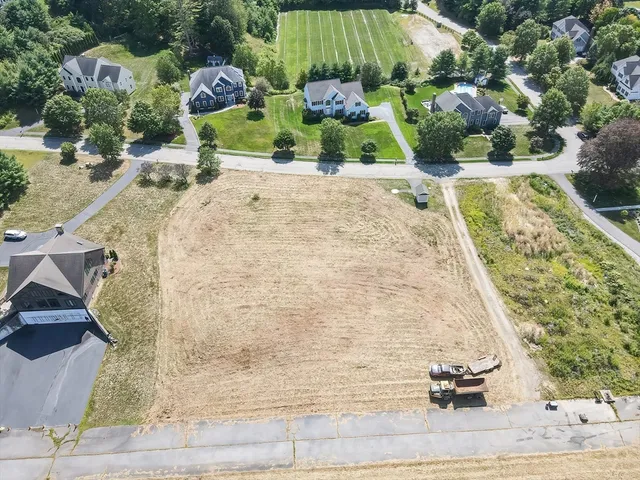 an aerial view of a house with a yard and lake view