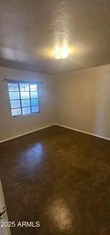 an empty room with wooden floor and windows in it