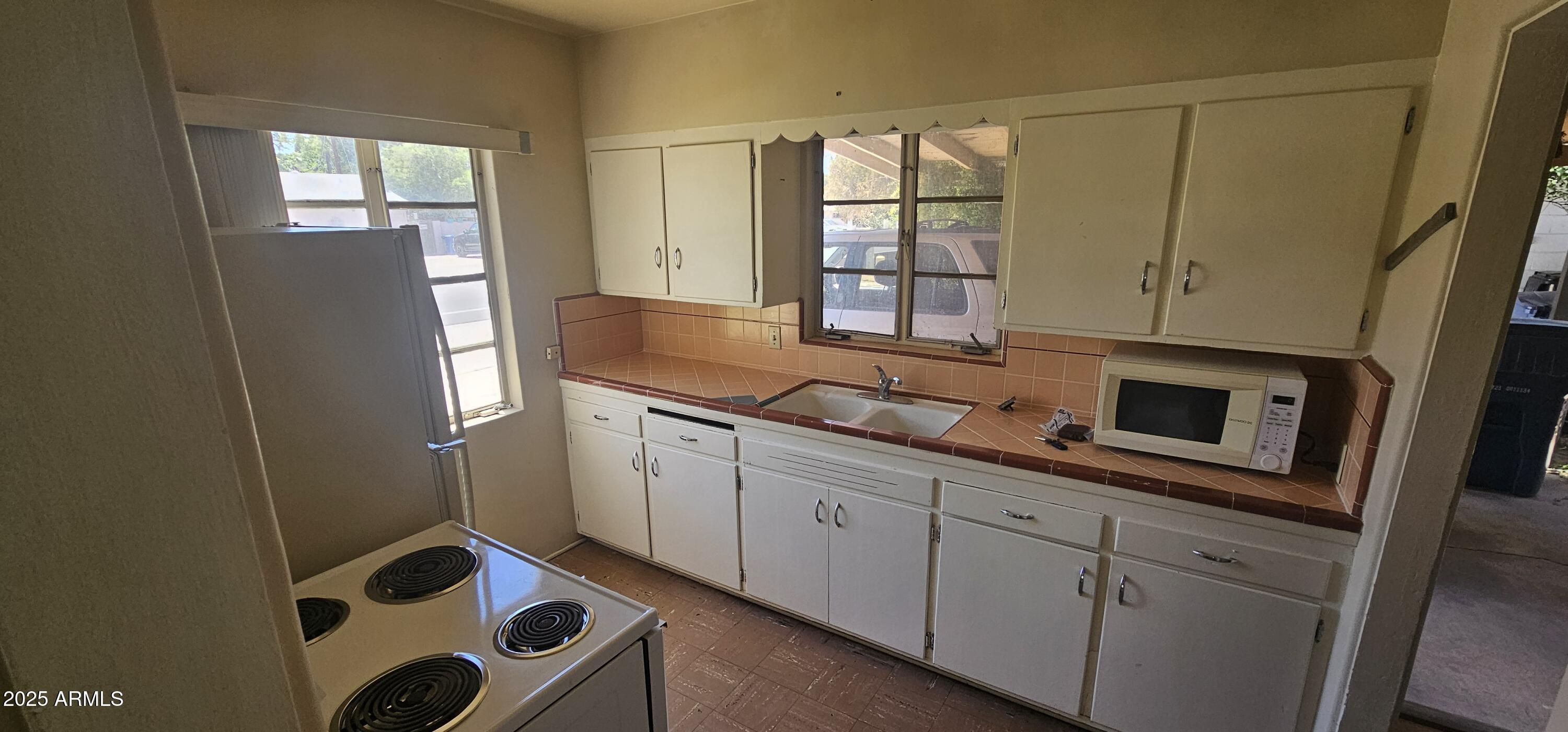 1234 South Farmer Avenue Tempe, AZ 85281 - Photo 3 of 47 a kitchen with stainless steel appliances a refrigerator sink and cabinets
