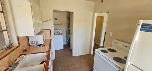 walk in closet with wooden floor washer and dryer