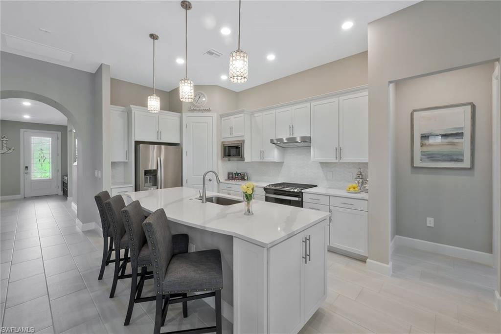 a kitchen with a dining table chairs refrigerator and microwave