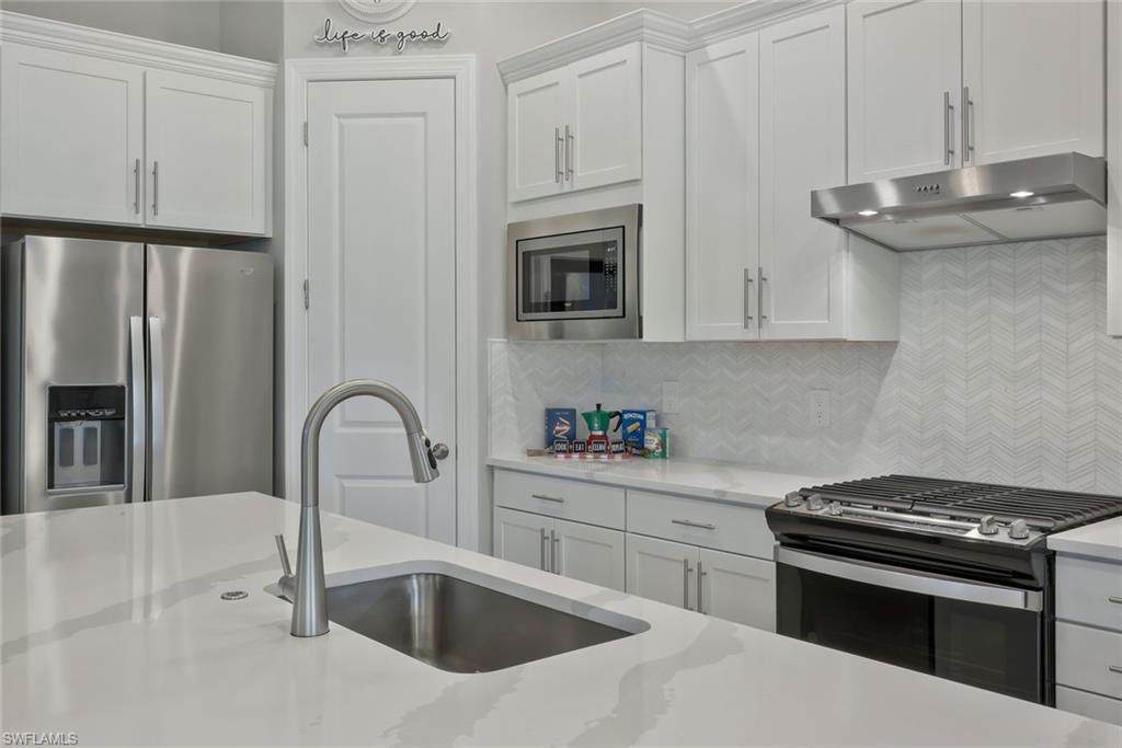 9640 Everglades Boulevard North Naples, FL 34120 - Photo 11 of 49 a kitchen with stainless steel appliances granite countertop a sink stove and refrigerator