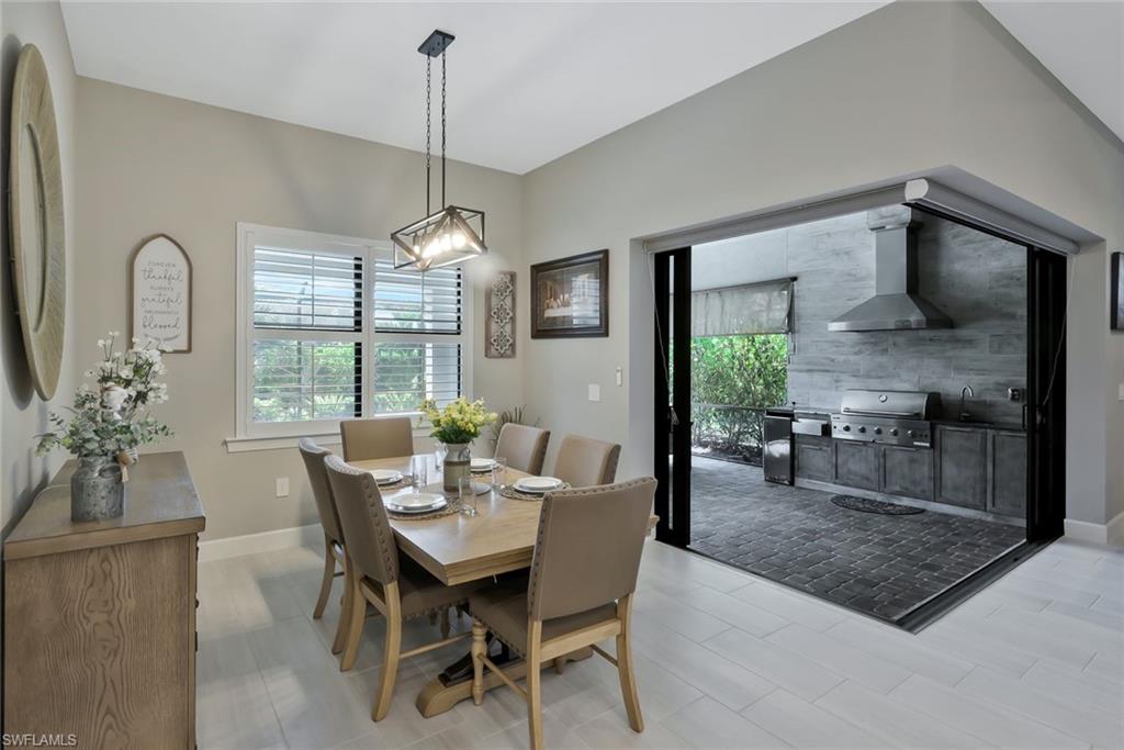 9640 Everglades Boulevard North Naples, FL 34120 - Photo 12 of 49 a dining room with furniture a chandelier and window