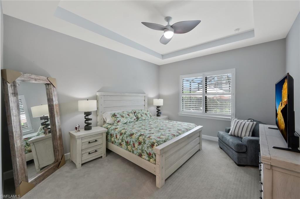 9640 Everglades Boulevard North Naples, FL 34120 - Photo 17 of 49 a bedroom with a bed couch and flat screen tv
