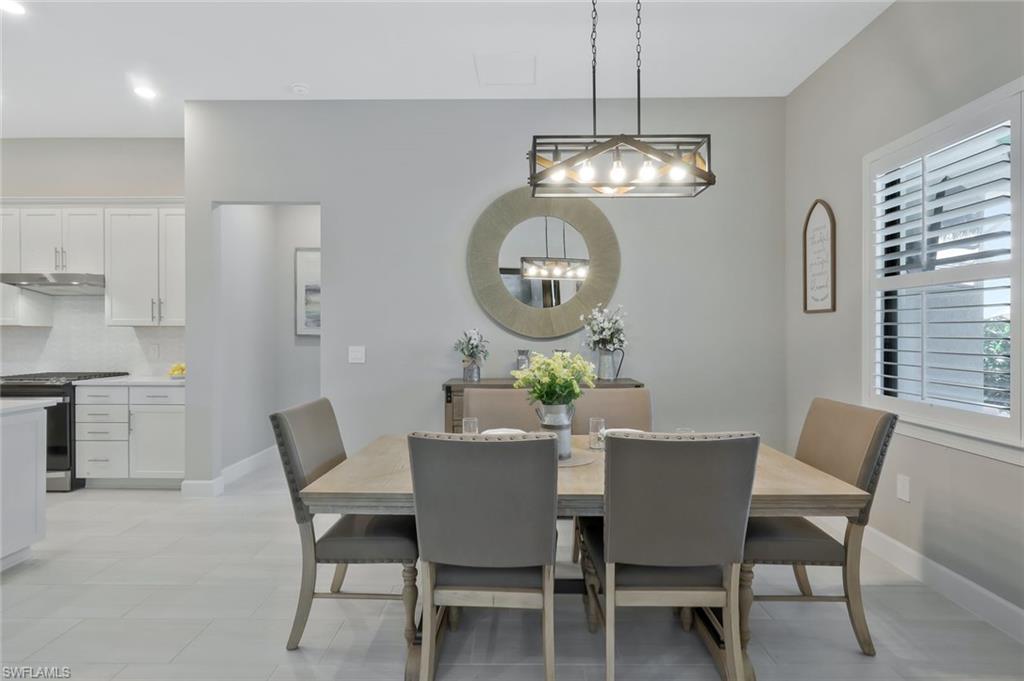 9640 Everglades Boulevard North Naples, FL 34120 - Photo 8 of 49 a view of a dining room with furniture a chandelier and wooden floor