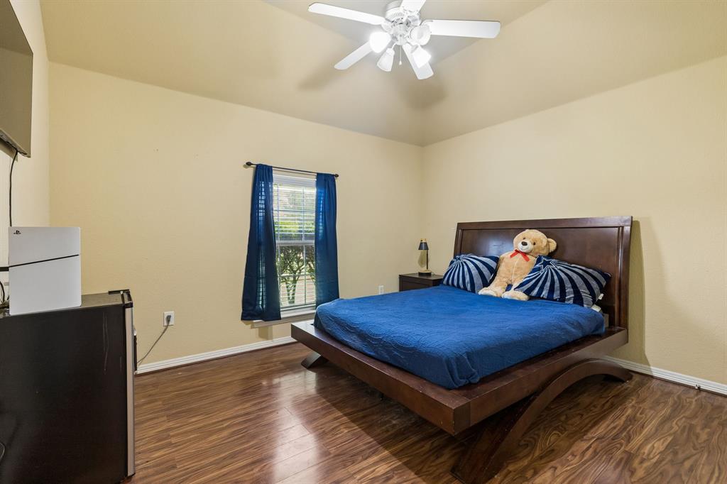 317 Singing Quail Trail Haslet, TX 76052 - Photo 21 of 32 Bedroom featuring vaulted ceilings, wood-finish flooring, a ceiling fan with integrated lighting, a single window, and baseboard molding