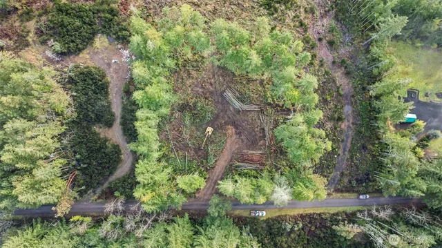 an aerial view of residential house with outdoor space and trees all around