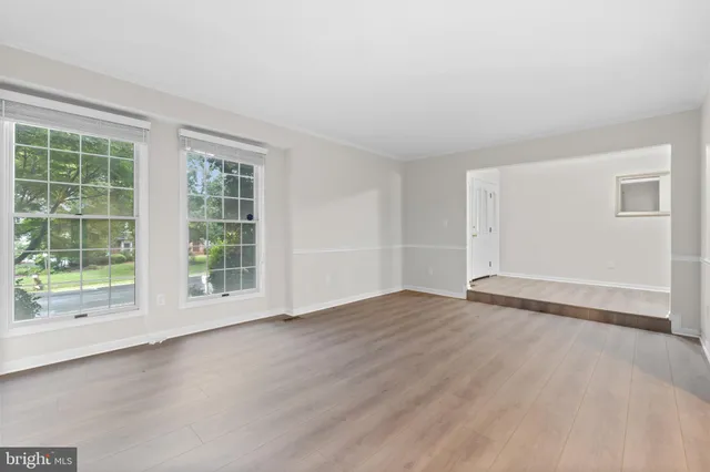 a view of hallway with wooden floor and chandelier