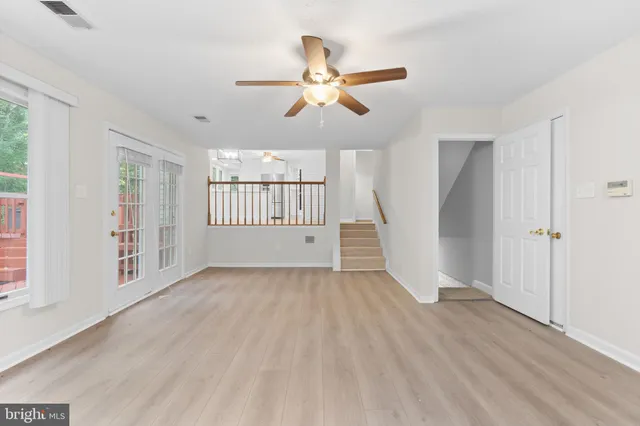 a view of an empty room with a fireplace and a fan