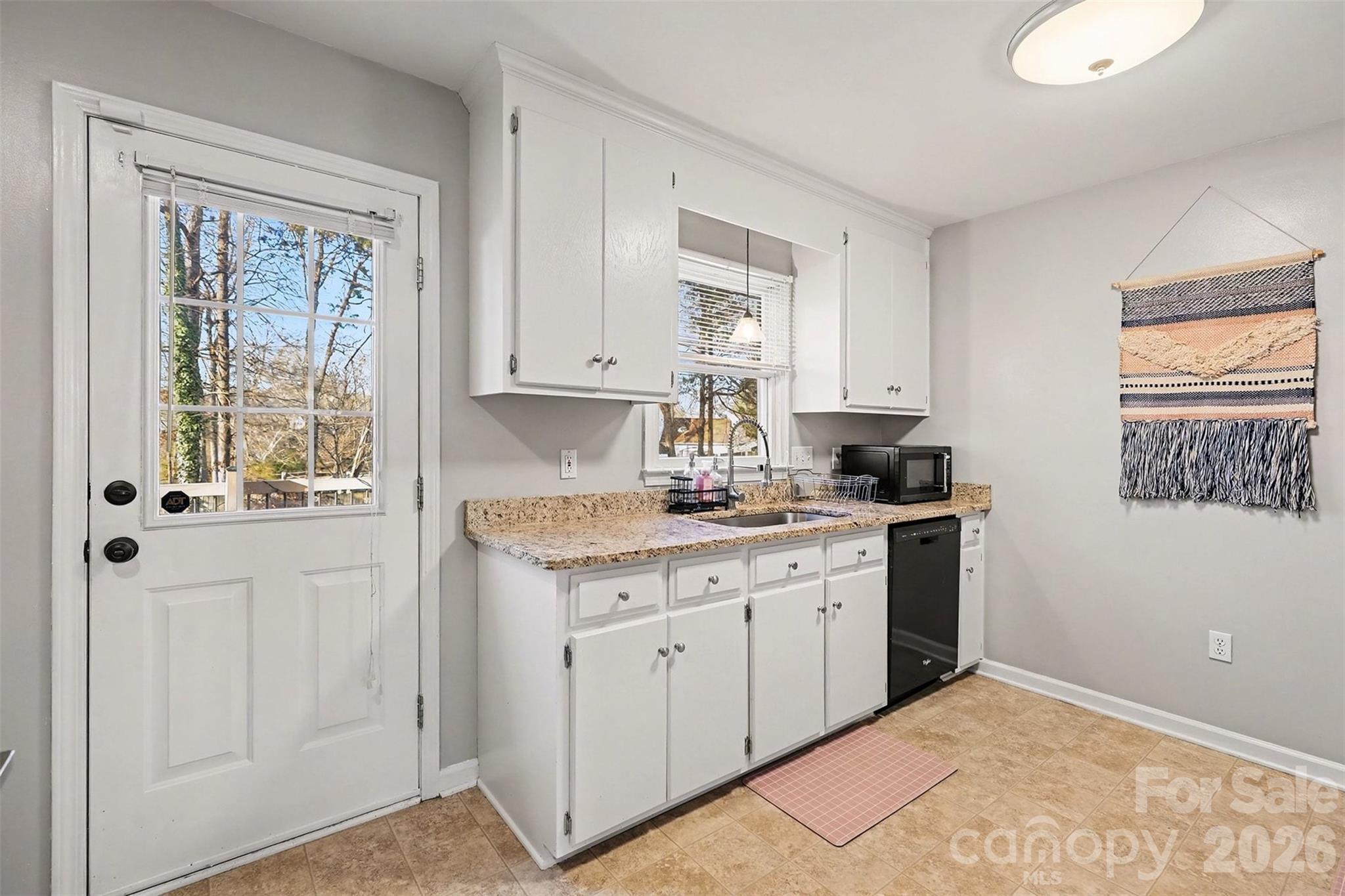 1318 Ridgewood Drive Concord, NC 28027 - Photo 6 of 27 a kitchen with granite countertop white cabinets and white appliances