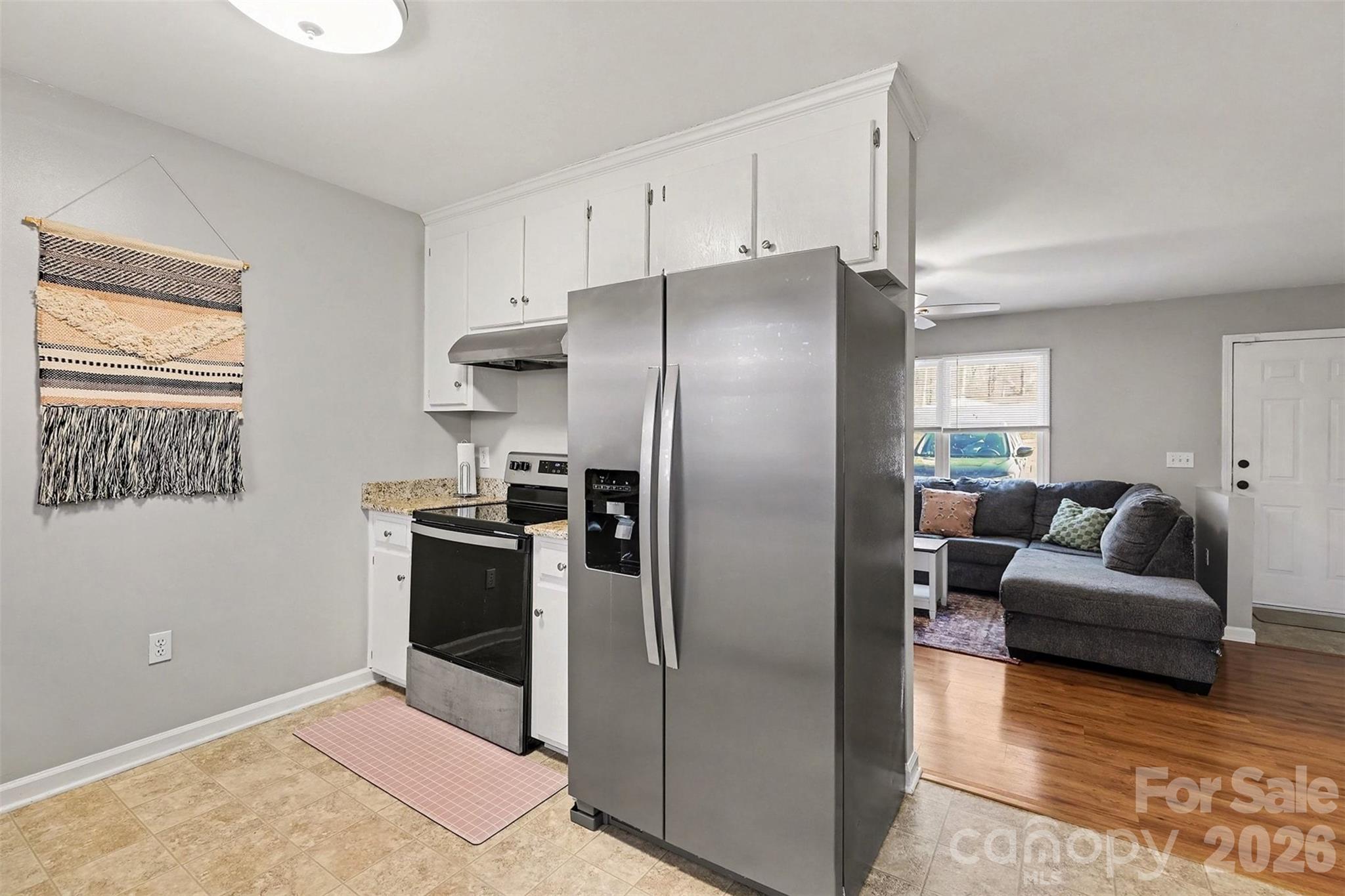 1318 Ridgewood Drive Concord, NC 28027 - Photo 8 of 27 a kitchen with a refrigerator and a couch