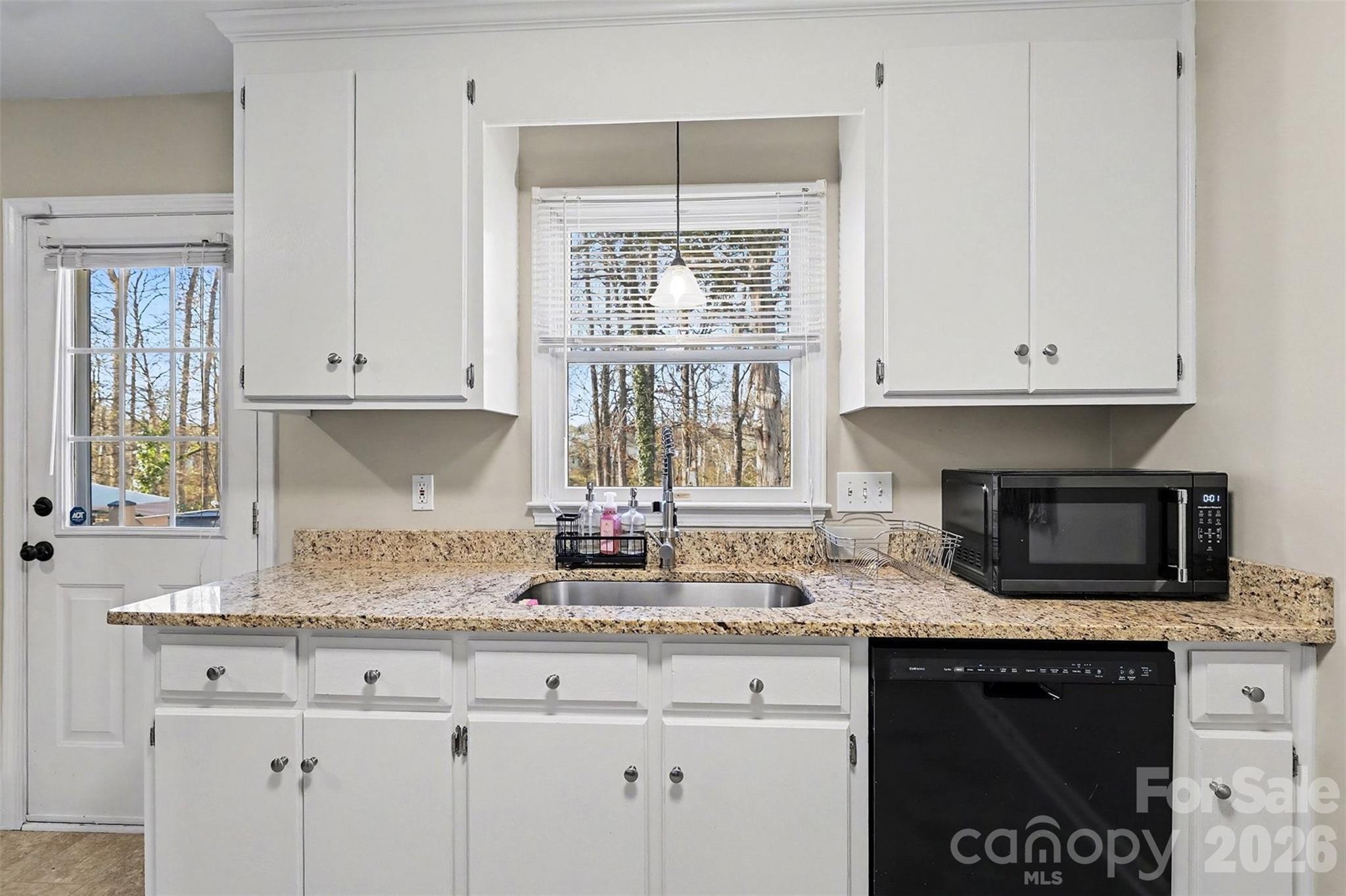 1318 Ridgewood Drive Concord, NC 28027 - Photo 9 of 27 a kitchen with granite countertop a stove a sink and a microwave