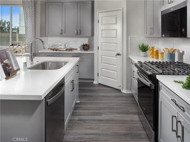 a kitchen with granite countertop a sink stove and cabinets