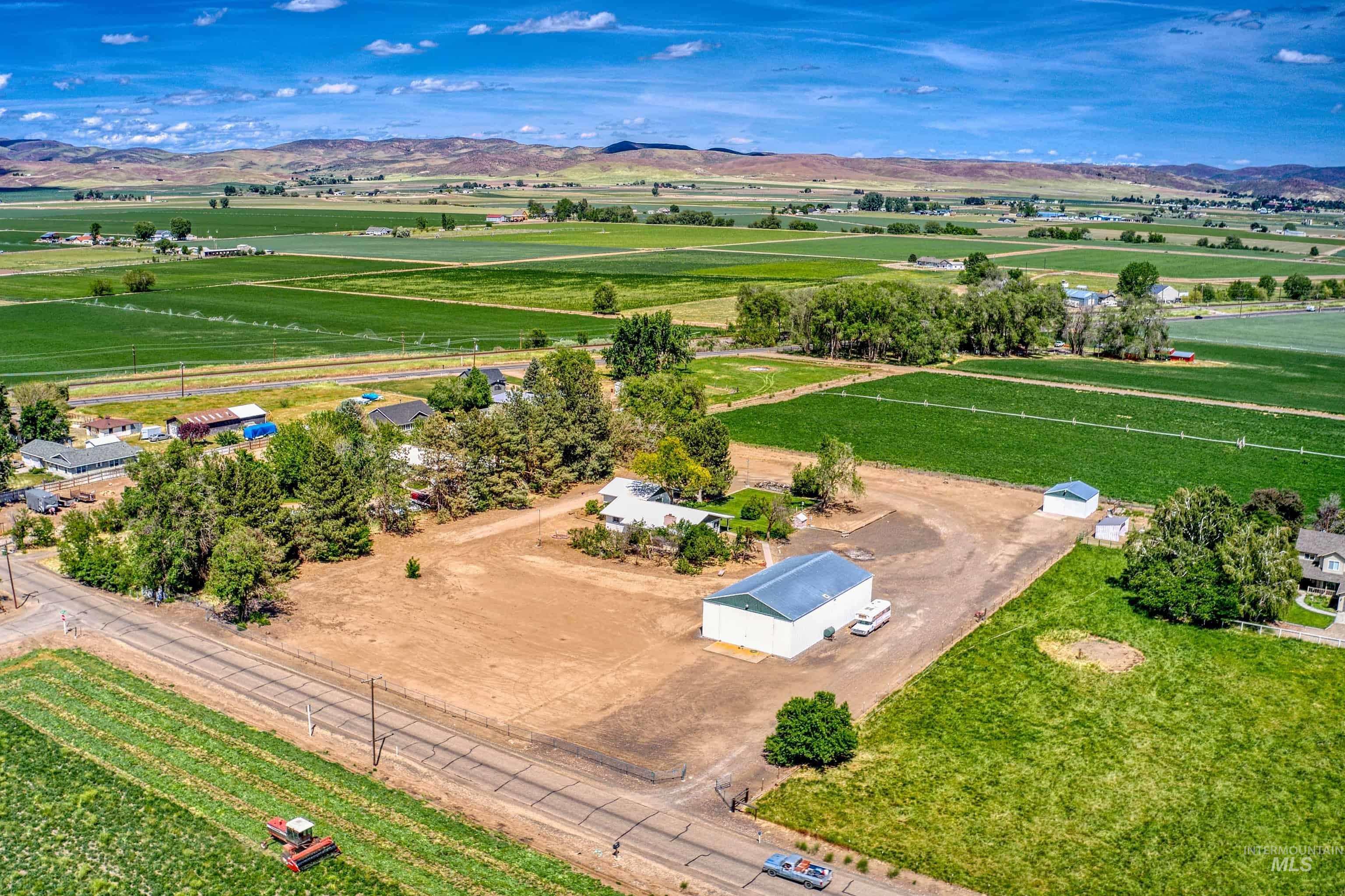 748 Pringle Road Weiser, ID 83672 - Photo 46 of 47 Expansive rural property featuring a large metal building with a blue roof, mature trees, and a spacious lot