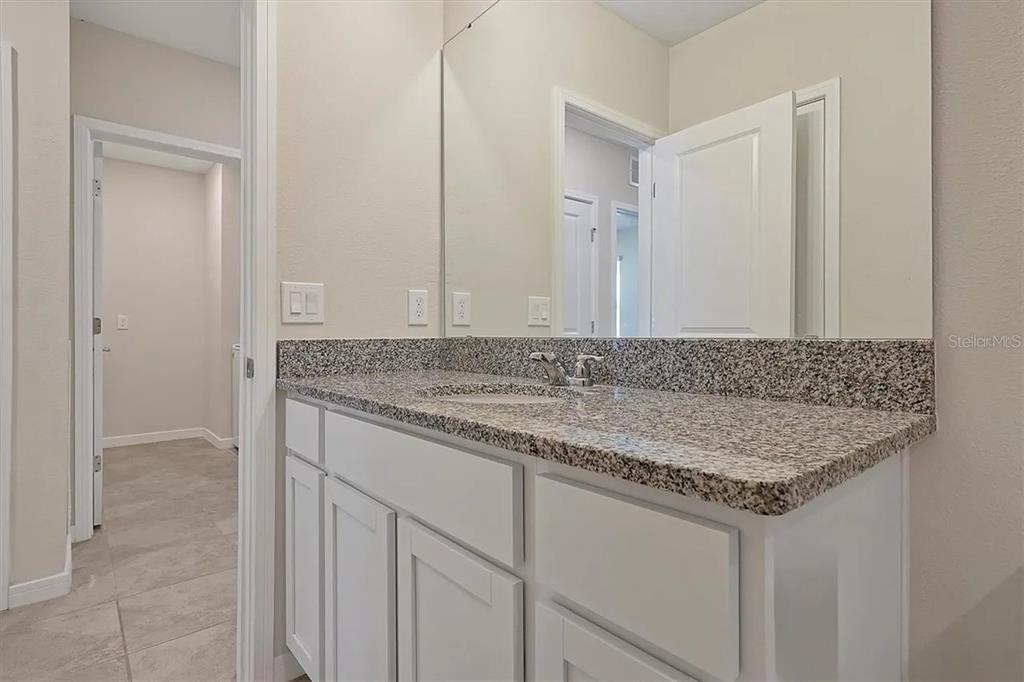 929 Rivers Crossing Street Clermont, FL 34714 - Photo 11 of 31 a bathroom with a granite countertop sink and a mirror