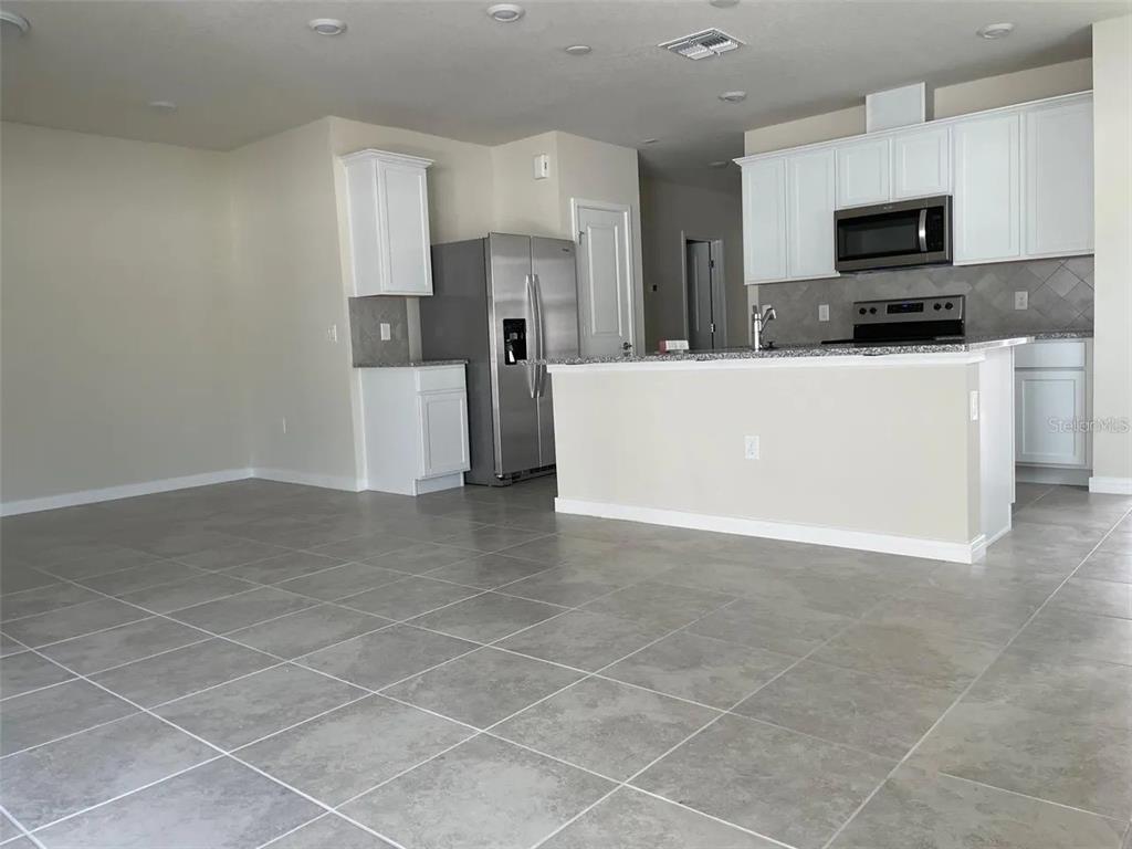 929 Rivers Crossing Street Clermont, FL 34714 - Photo 3 of 31 a view of kitchen with stainless steel appliances a refrigerator sink and microwave