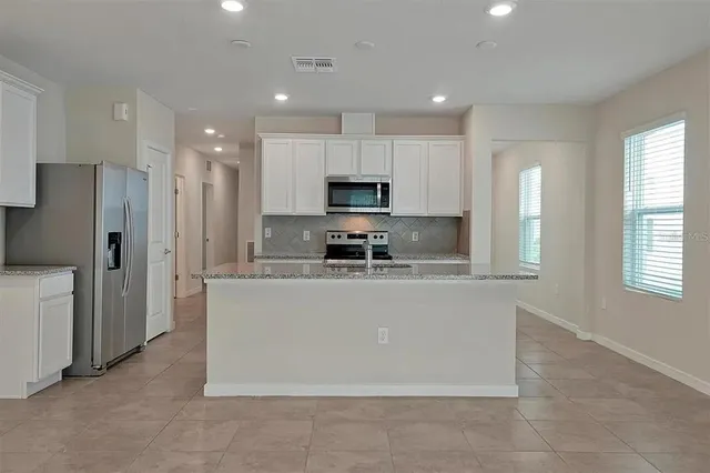 a large kitchen with stainless steel appliances granite countertop a granite counter tops and a stove top oven