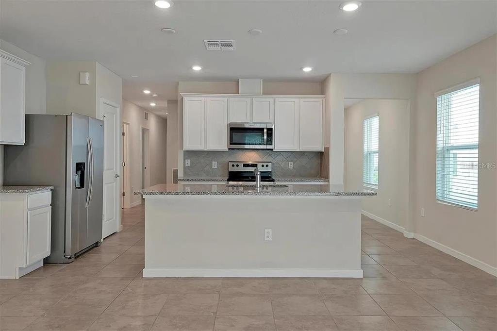 929 Rivers Crossing Street Clermont, FL 34714 - Photo 5 of 31 a large kitchen with stainless steel appliances granite countertop a granite counter tops and a stove top oven