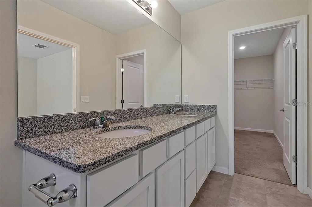 929 Rivers Crossing Street Clermont, FL 34714 - Photo 6 of 31 a bathroom with a granite countertop sink and a mirror